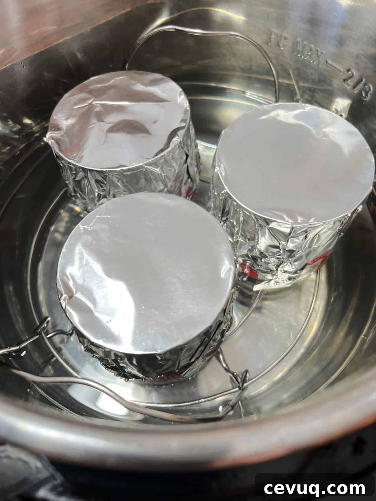 3 cans of sweetened condensed milk covered in foil ready to cook.