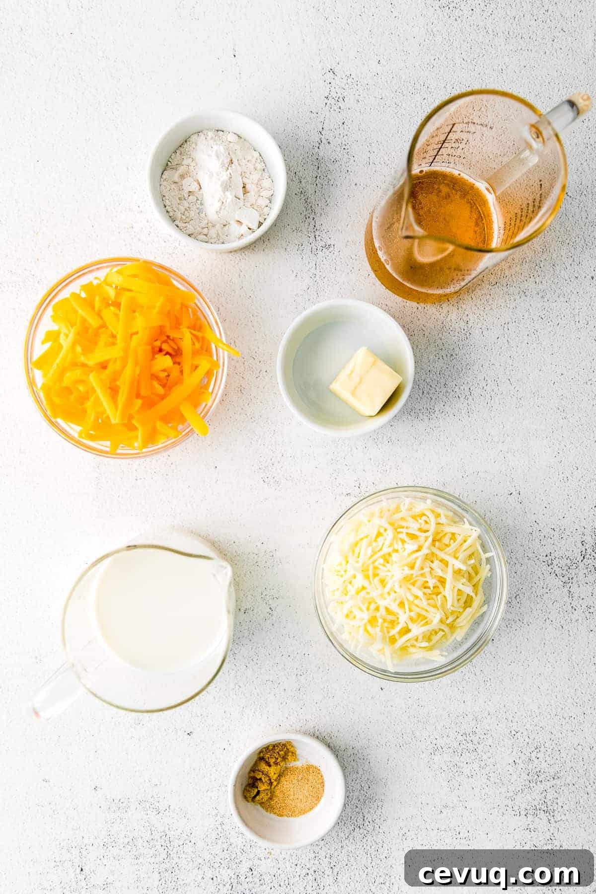 Cheddar cheese, mozzarella cheese, and other ingredients in small bowls.