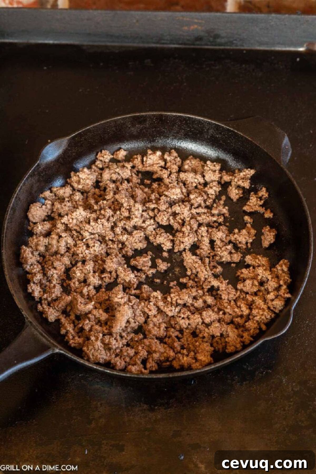 Ground beef in a cast iron skillet on the griddle