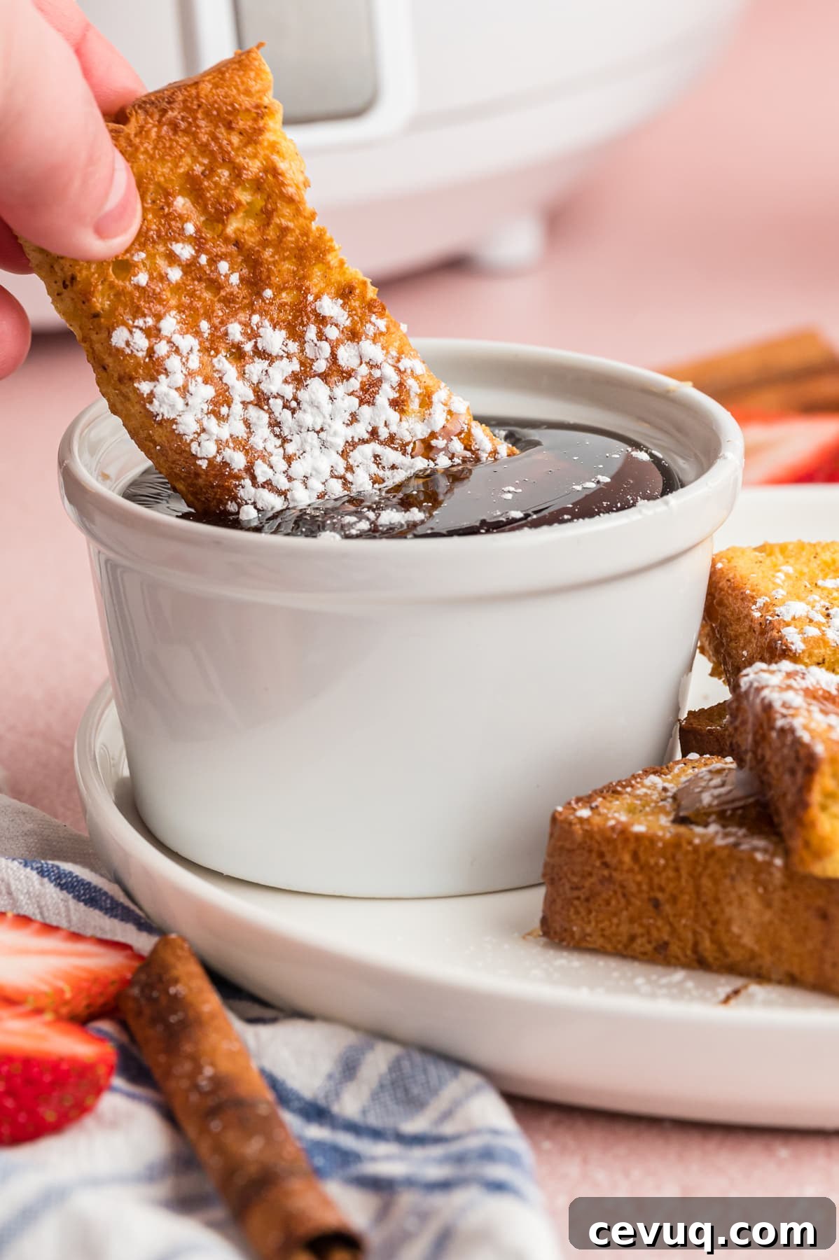 A French toast stick dipped in syrup