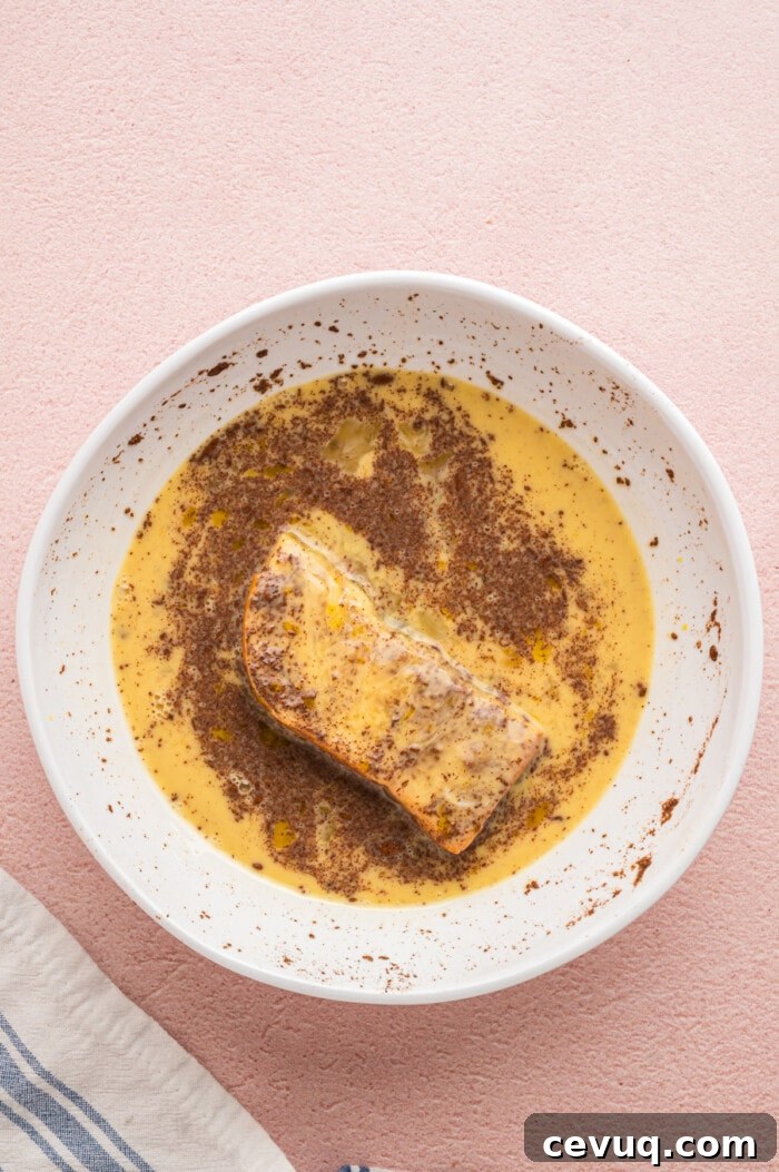 A third of a bread slice dipped into egg custard mixture