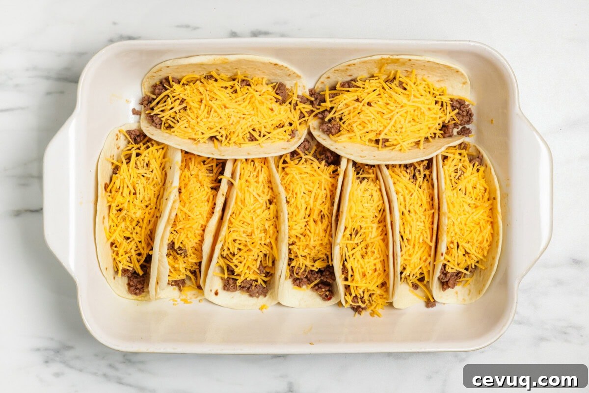 flour tortillas with taco meat and cheese in 13x9 pan