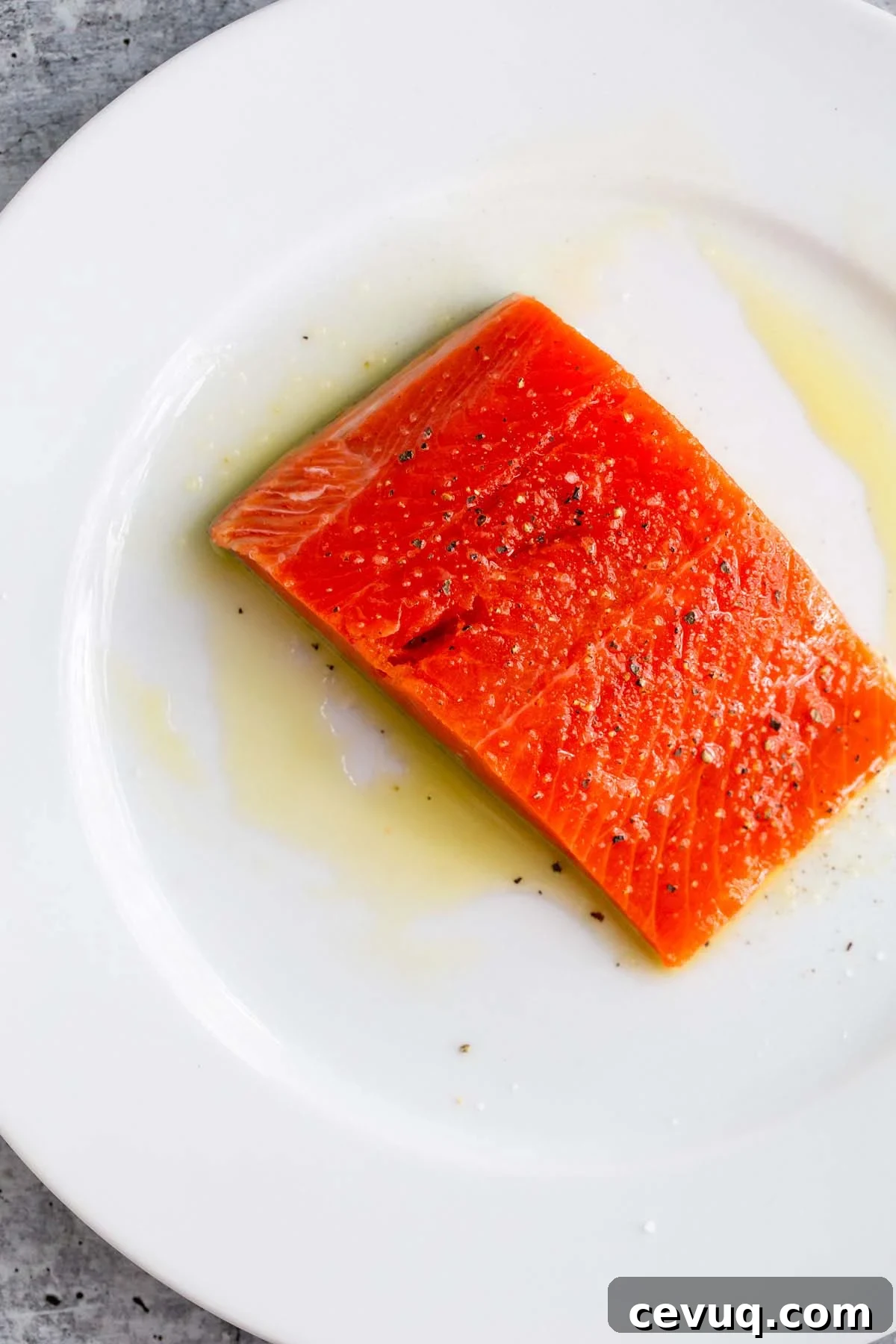 Uncooked salmon on a white plate.