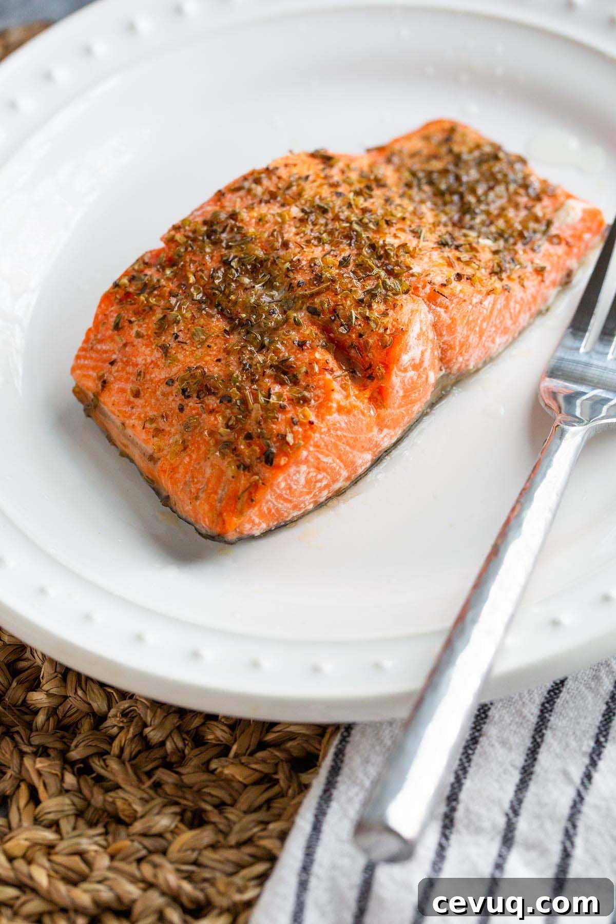 Cooked salmon on a plate up close with a fork.