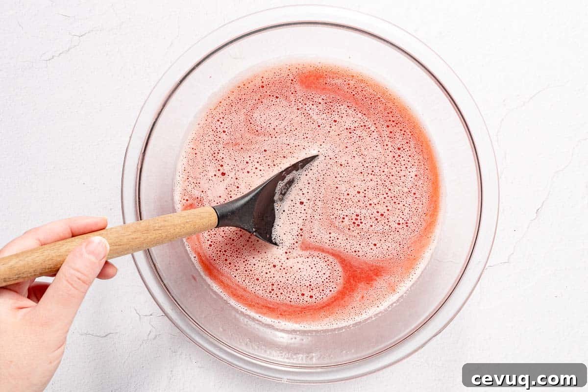 strawberry juice being stirred in glass bowl
