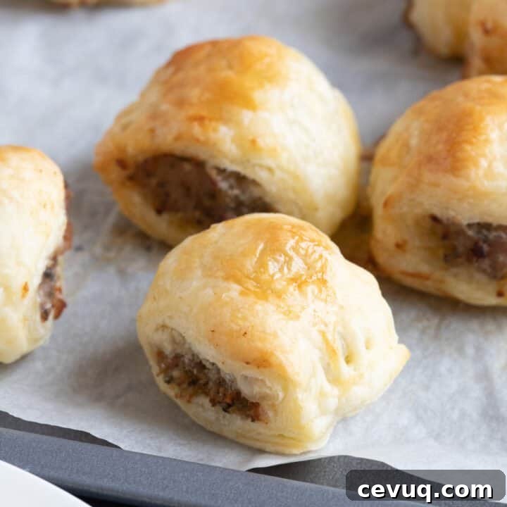 Mini sausage rolls on a baking sheet.