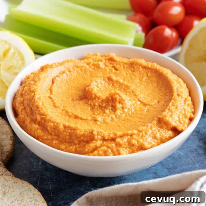 Roasted red pepper hummus with celery sticks.