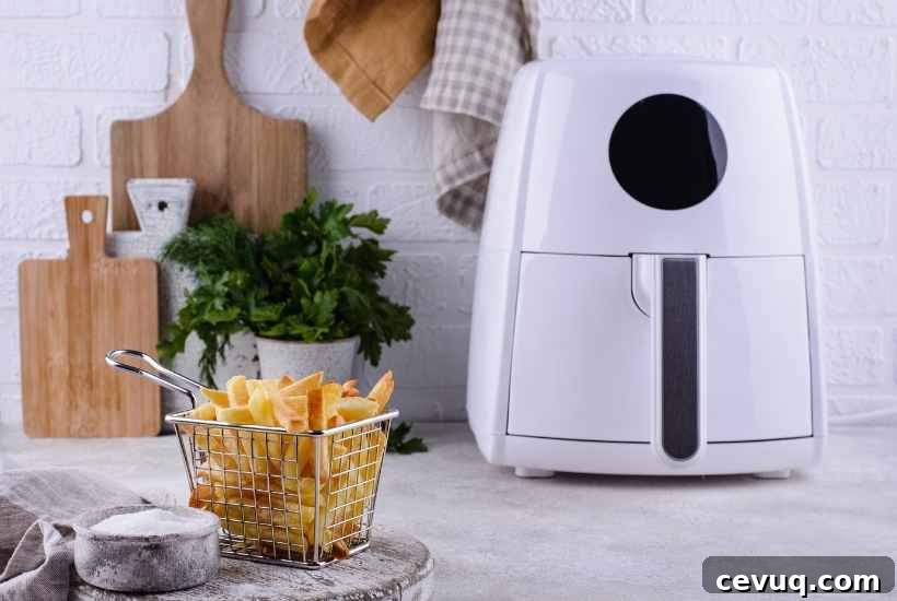 white air fryer sitting next to a basket of fries