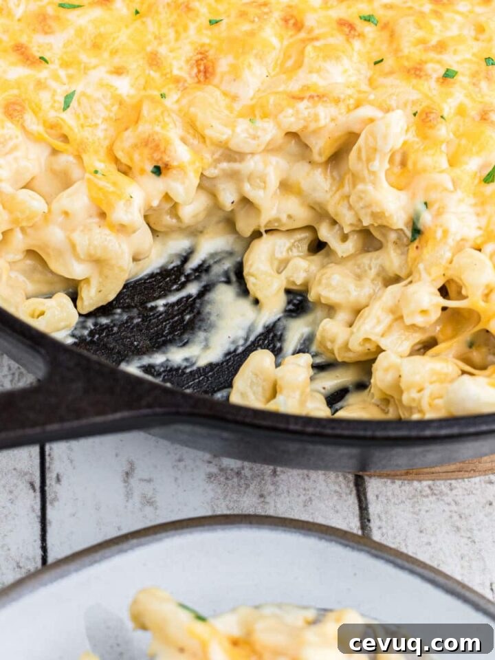 close up of a skillet of mac and cheese with some missing.
