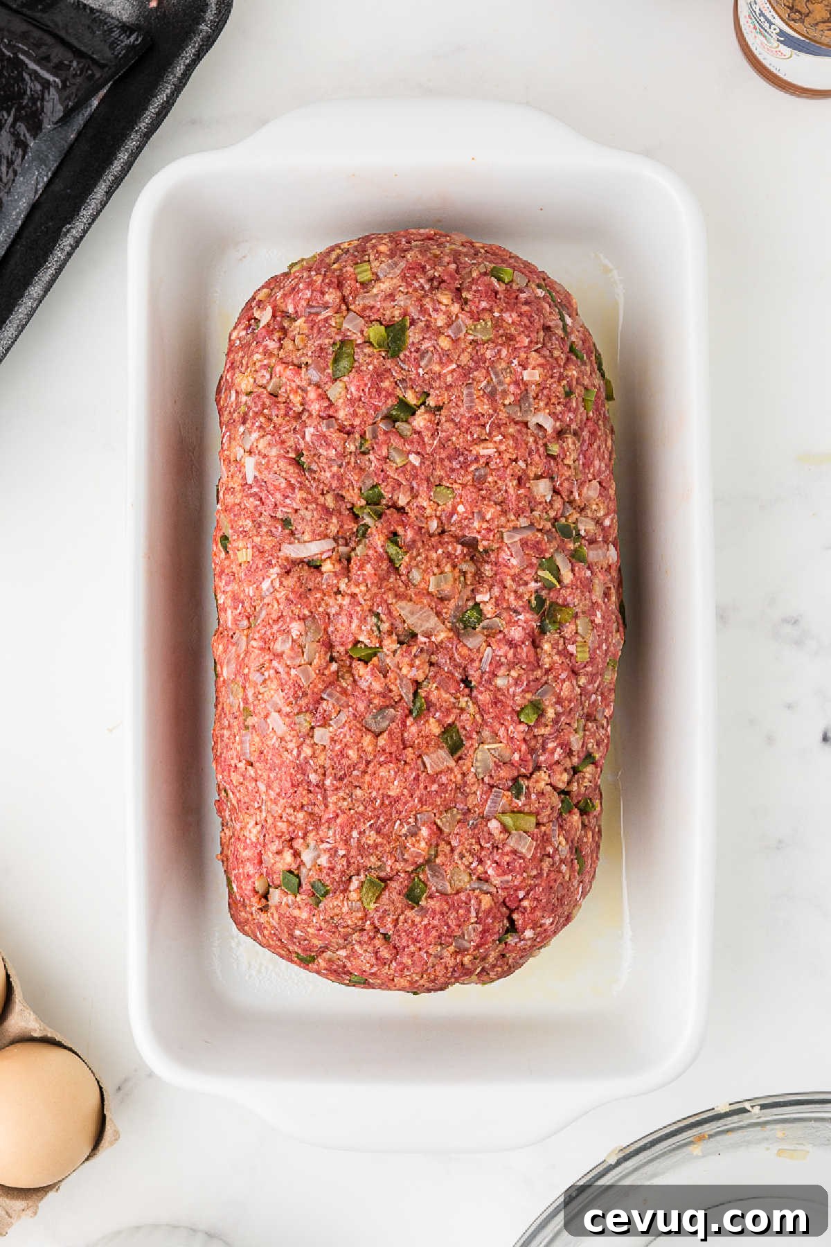A large meatloaf about to be baked in the oven.