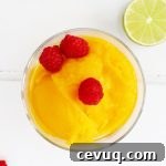 Mango sorbet in a bowl with raspberries