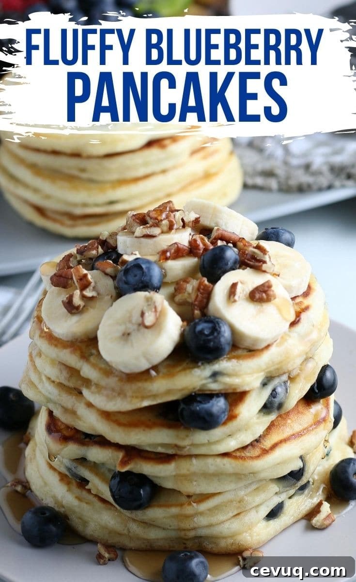 A stack of blueberry pancakes topped with bananas, blueberries, and walnuts