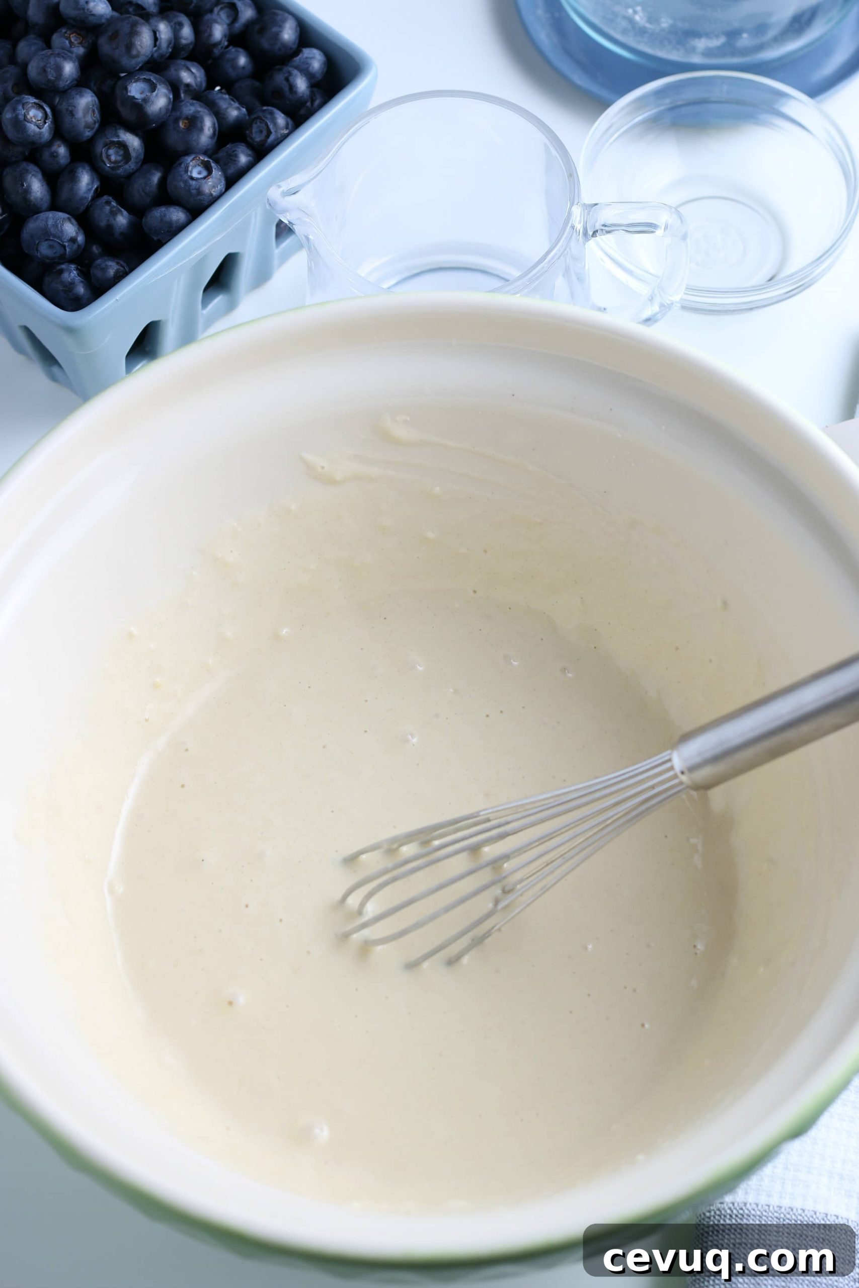mixed pancake batter in a white glass bowl
