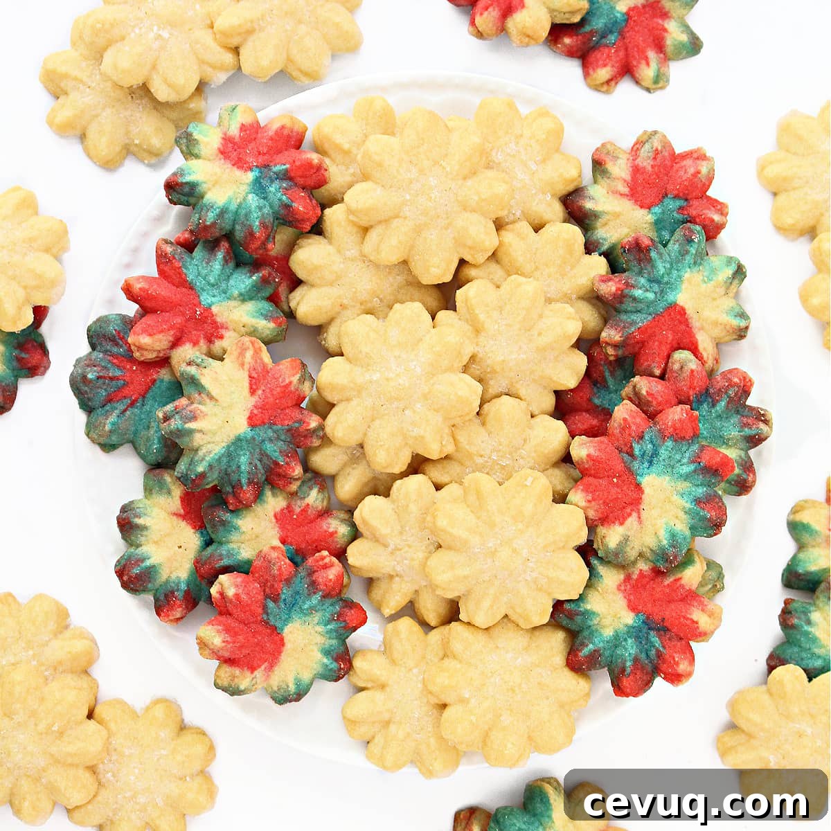 Classic Spritz Cookie Recipe Using Shortening for Crispy Shapes 6 Spritz cookies in flower shapes on a plate.