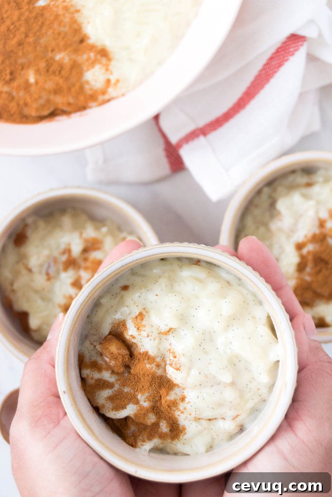 A woman holds a bowl of Rice Pudding with Condensed Milk above three other bowls