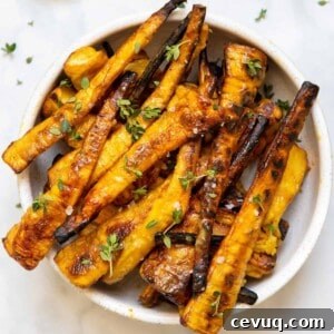 Crispy Roasted Parsnips with Honey and Thyme 12 mustard maple glazed parsnips in white bowl on backdrop