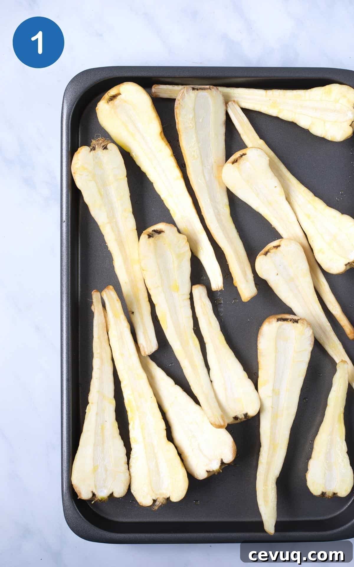 Crispy Roasted Parsnips with Honey and Thyme 4 slice parsnips on baking tray with olive oil and salt ready to bake.
