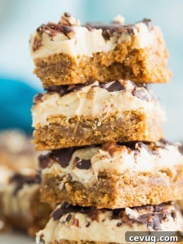 A stack of four turtle cookie bars and the top one has a bite out of it.