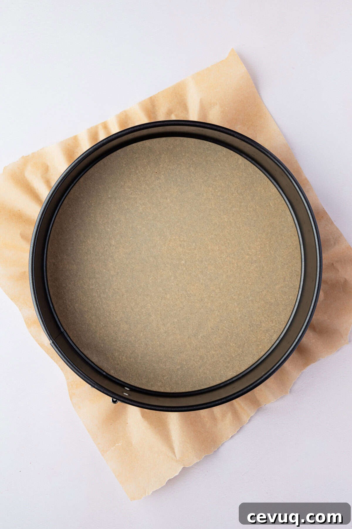 A springform pan lined with parchment paper.