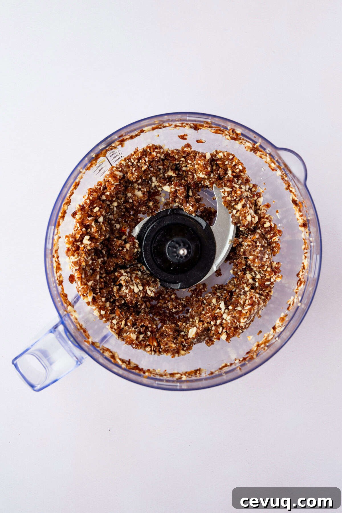 A food processor with ground nuts in it.