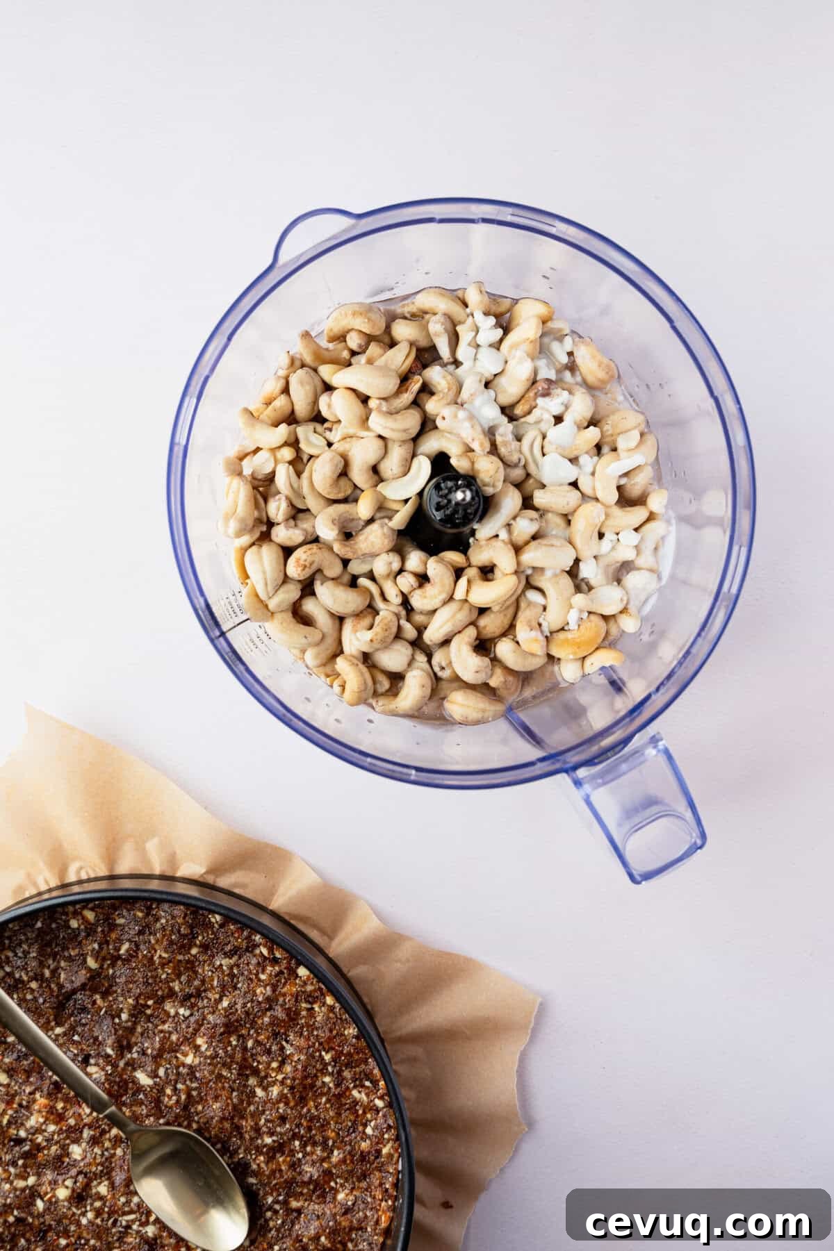 A food processor filled with raw cashews and coconut milk.