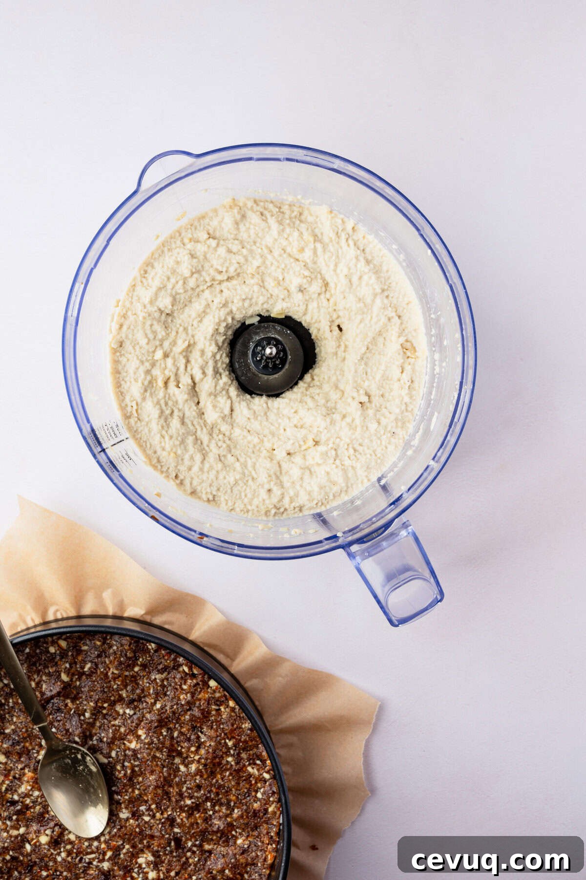 A food processor filled with a white creamy sauce.