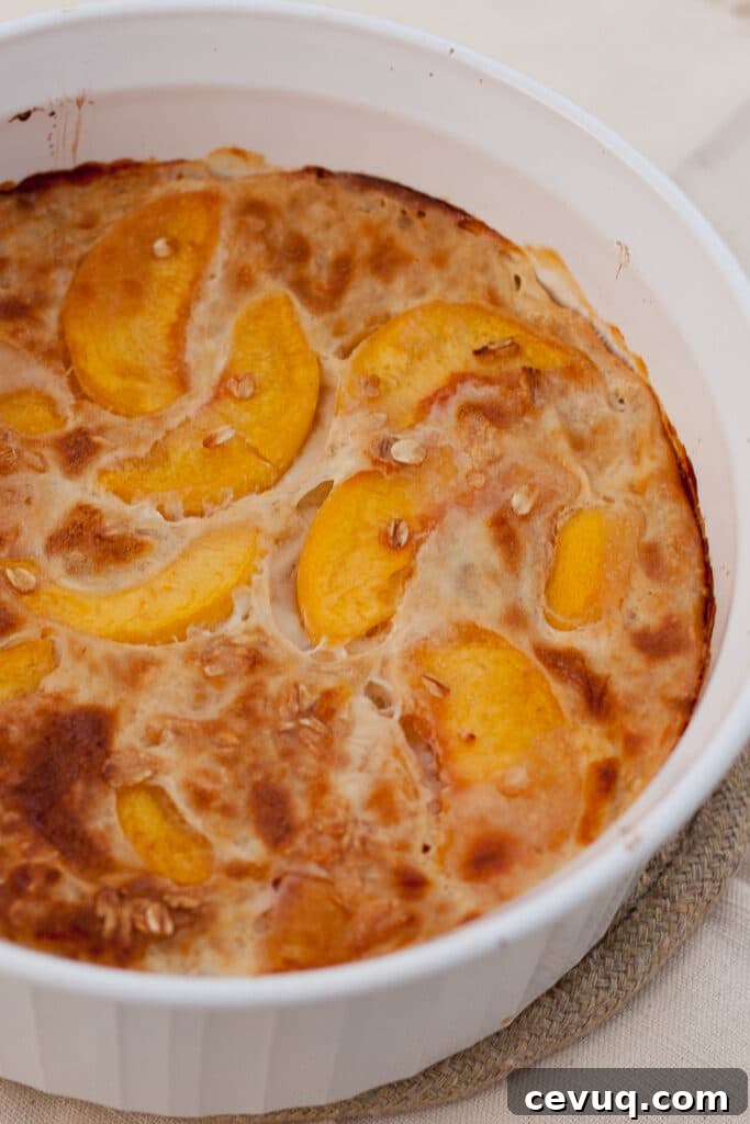 a large casserole dish filled with baked oatmeal with peaches in it.