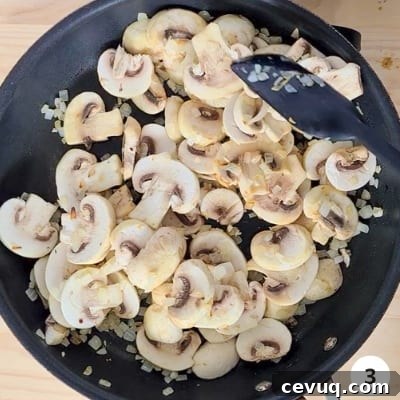Creamy Mushroom Pasta Without Cream — Dairy-Free Recipe 6 stirring mushrooms cooking in a skillet