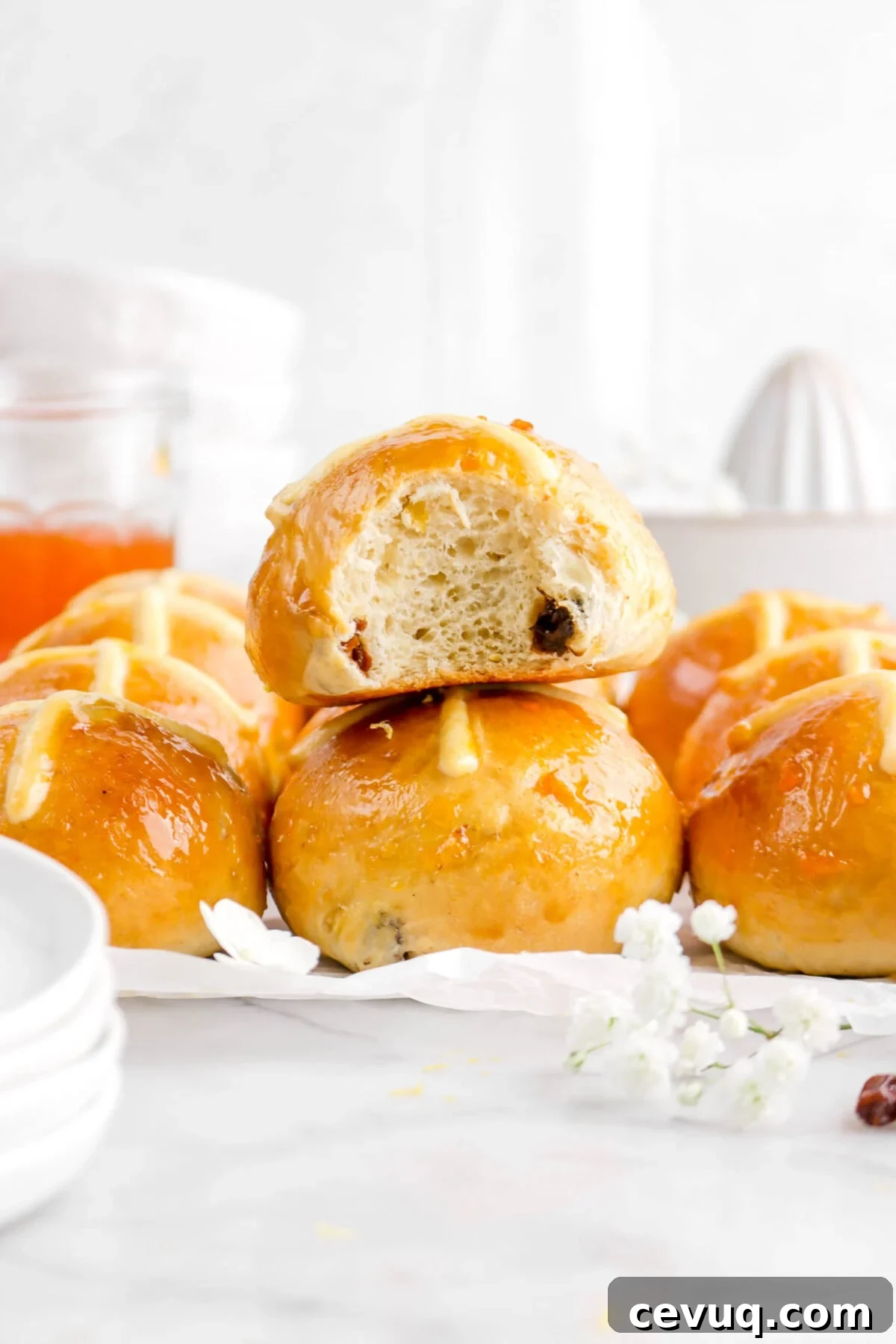 hot cross bun with bite missing stacked on top of another bun with more around and behind