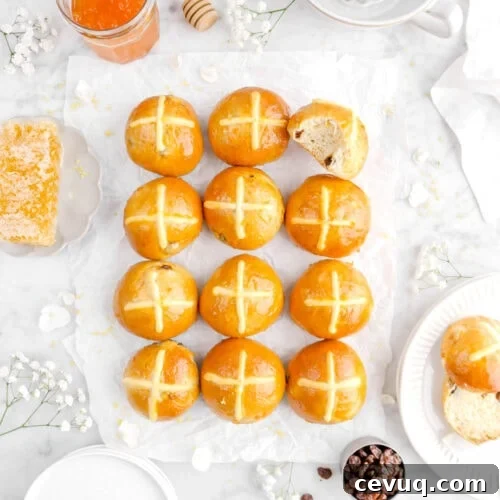 overhead of twelve hot cross buns with bite taken out of top right bun
