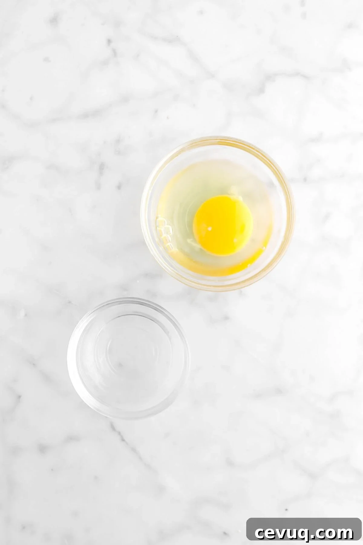 bowl of egg and bowl of water on marble counter