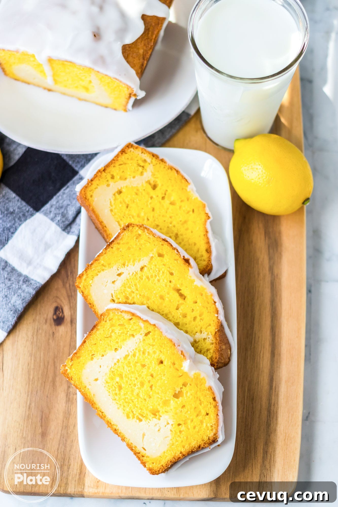 Overhead shot of sliced lemon cheesecake loaf cake served on a white plate