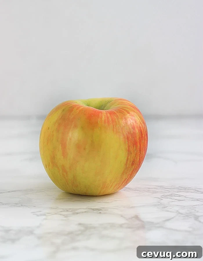 yellow and pink honeycrisp apple on a white background
