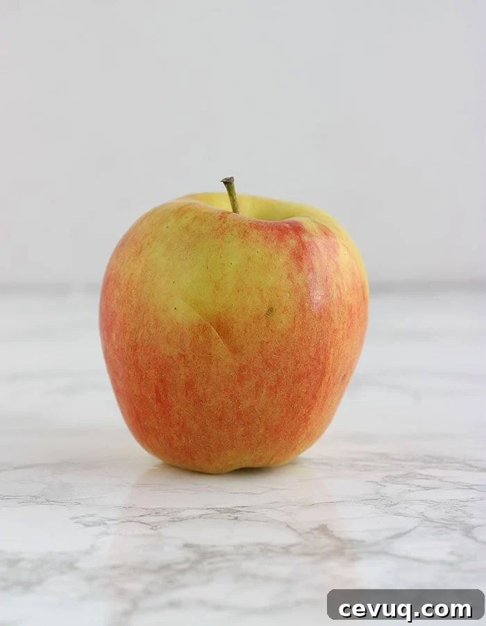 yellow and pink ambrosia apple on a white background