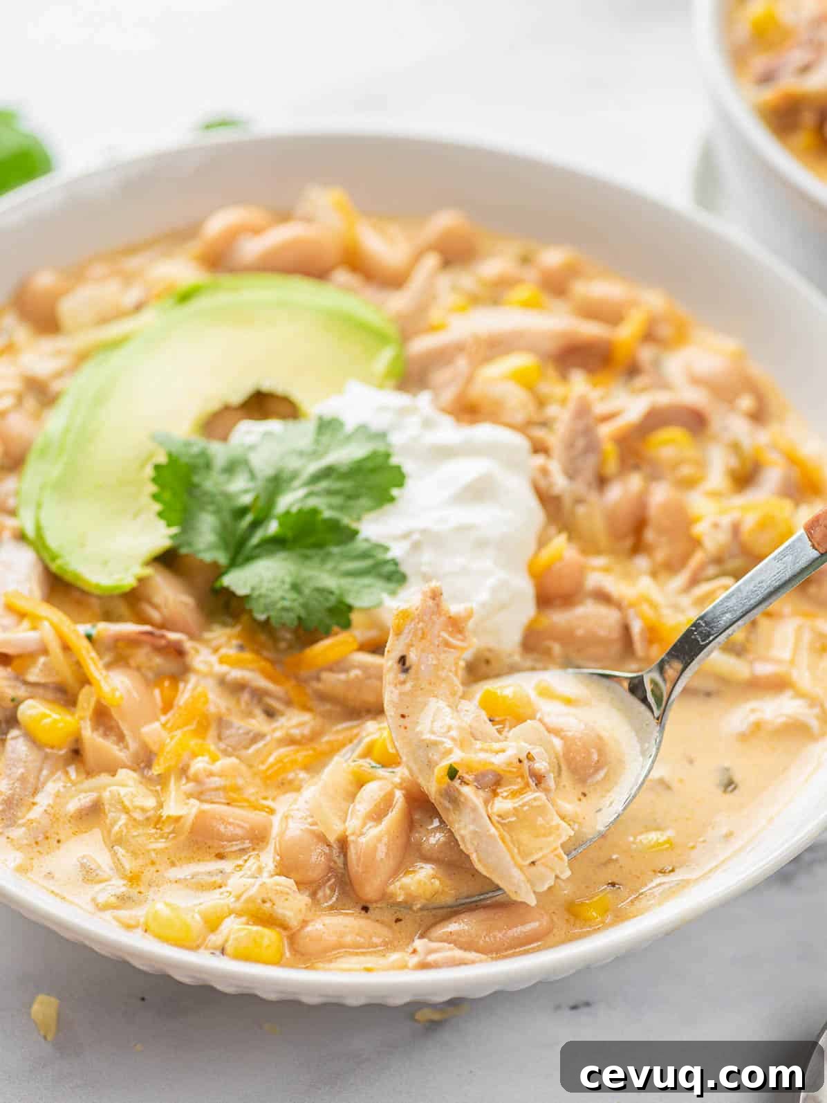 spoon scooping white chicken chili from plate