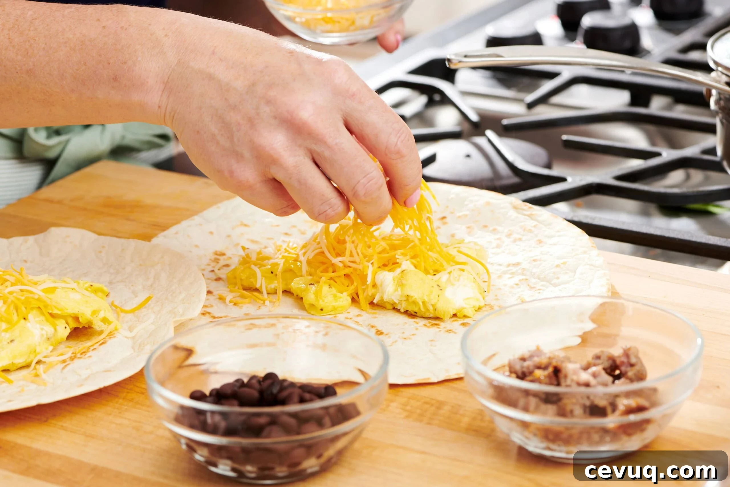 18 Delicious Recipes to Use Up Leftover Cheese 6 Woman placing shredded cheese onto eggs on a tortilla.