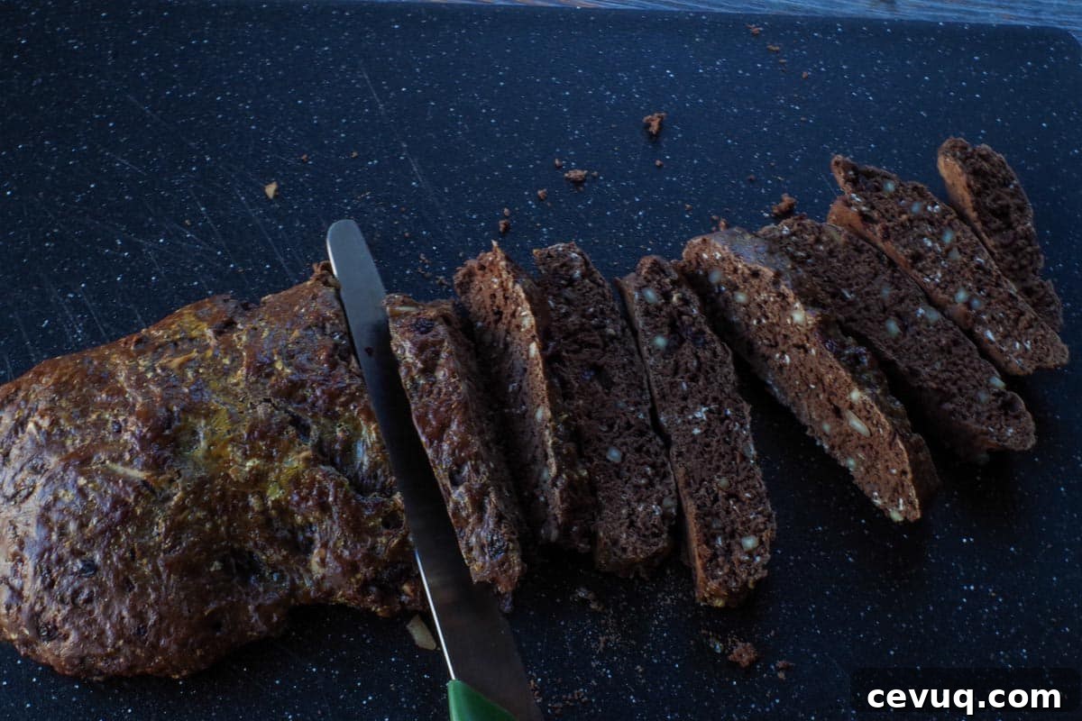 Chocolate Zucchini Biscotti Recipe: Crunchy, Moist, and Perfect for Coffee 12 biscotti being sliced on cutting board with serrated knife