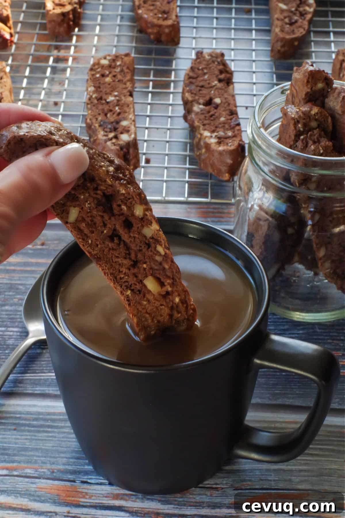Chocolate Zucchini Biscotti Recipe: Crunchy, Moist, and Perfect for Coffee 15 Zucchini Biscotti being dipped into a cup of coffee, with more zucchini on a wire rack in the background
