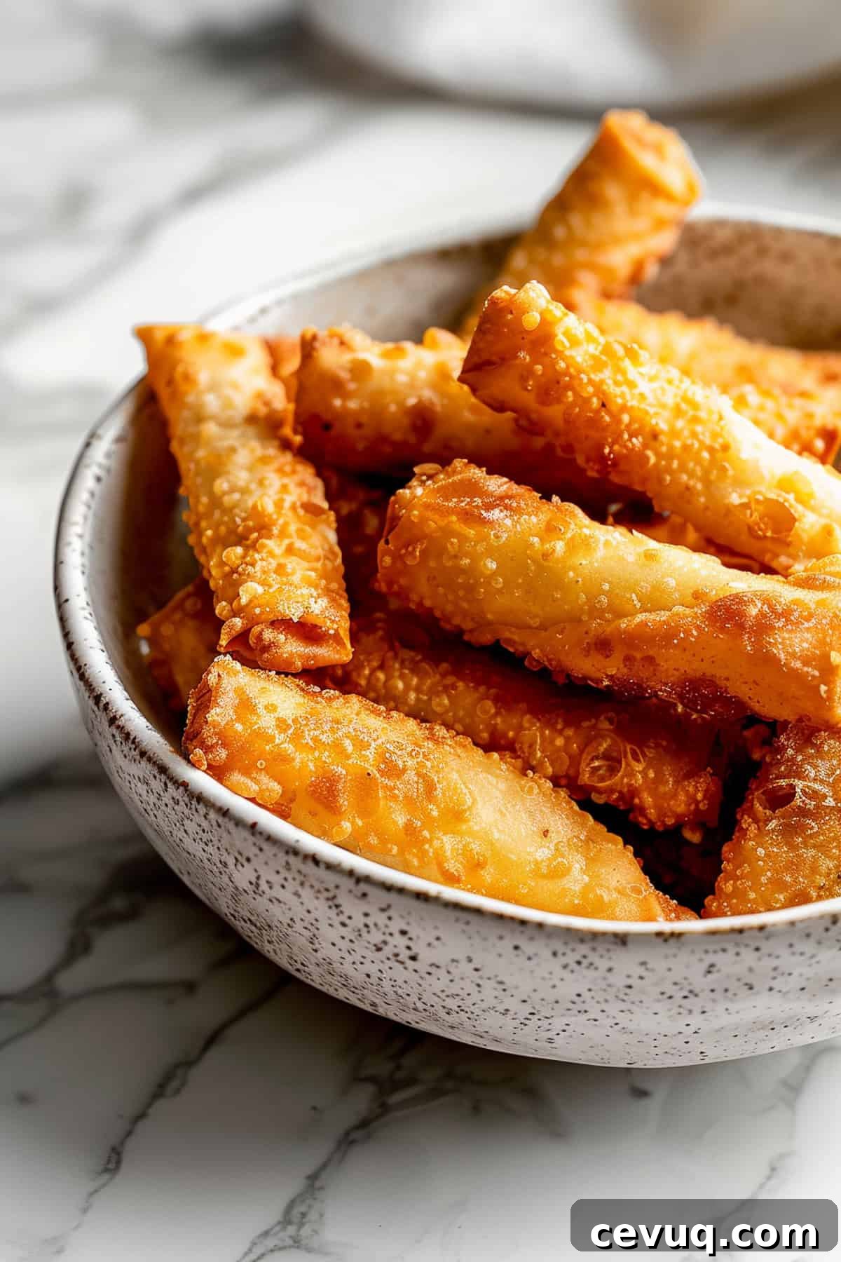 Crispy Homemade Egg Rolls: Step-by-Step Recipe for Perfect Rolls 2 Crispy fried homemade egg rolls in a white bowl.
