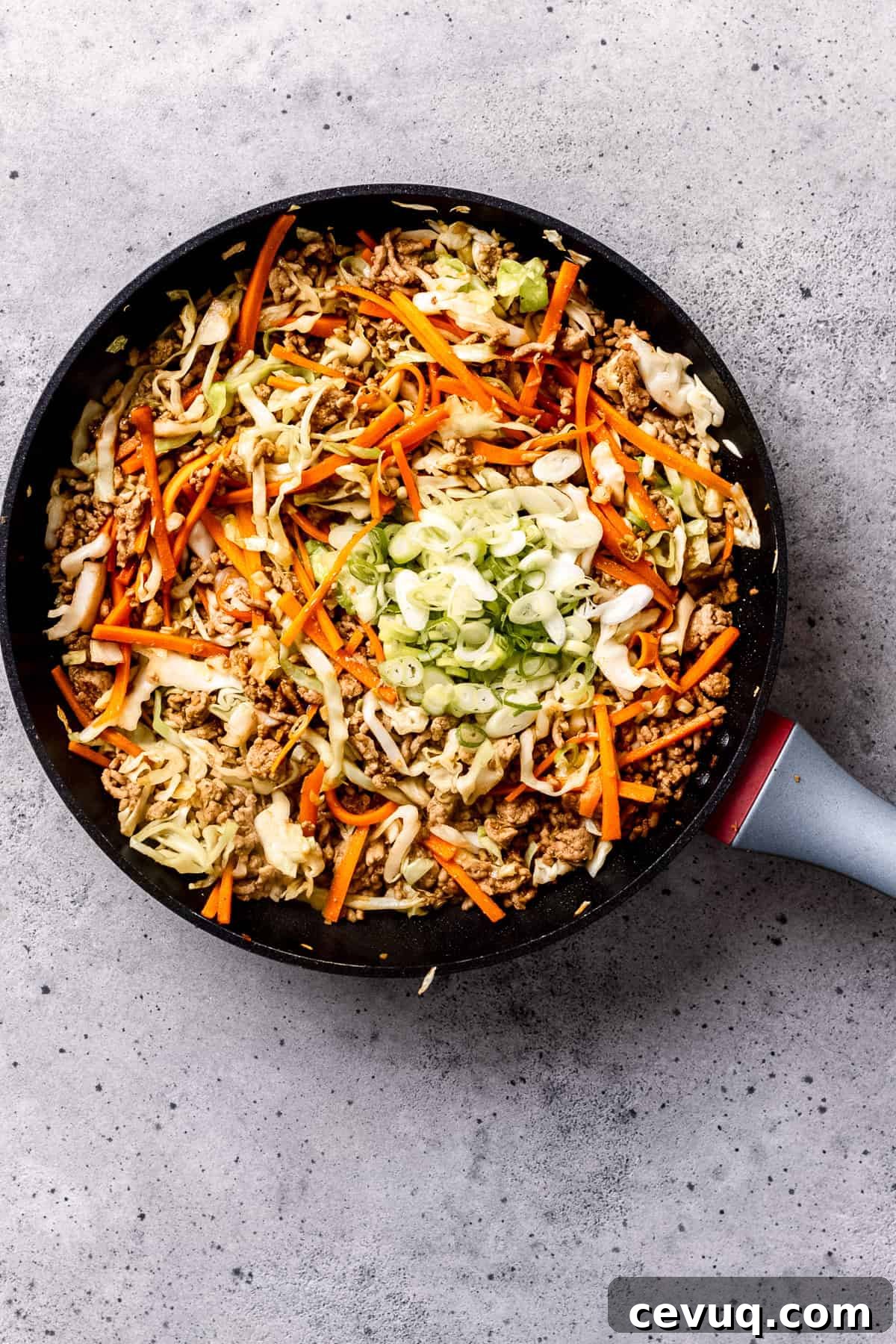 Crispy Homemade Egg Rolls: Step-by-Step Recipe for Perfect Rolls 7 Pork and vegetables being sautéed for homemade egg rolls in a pan.