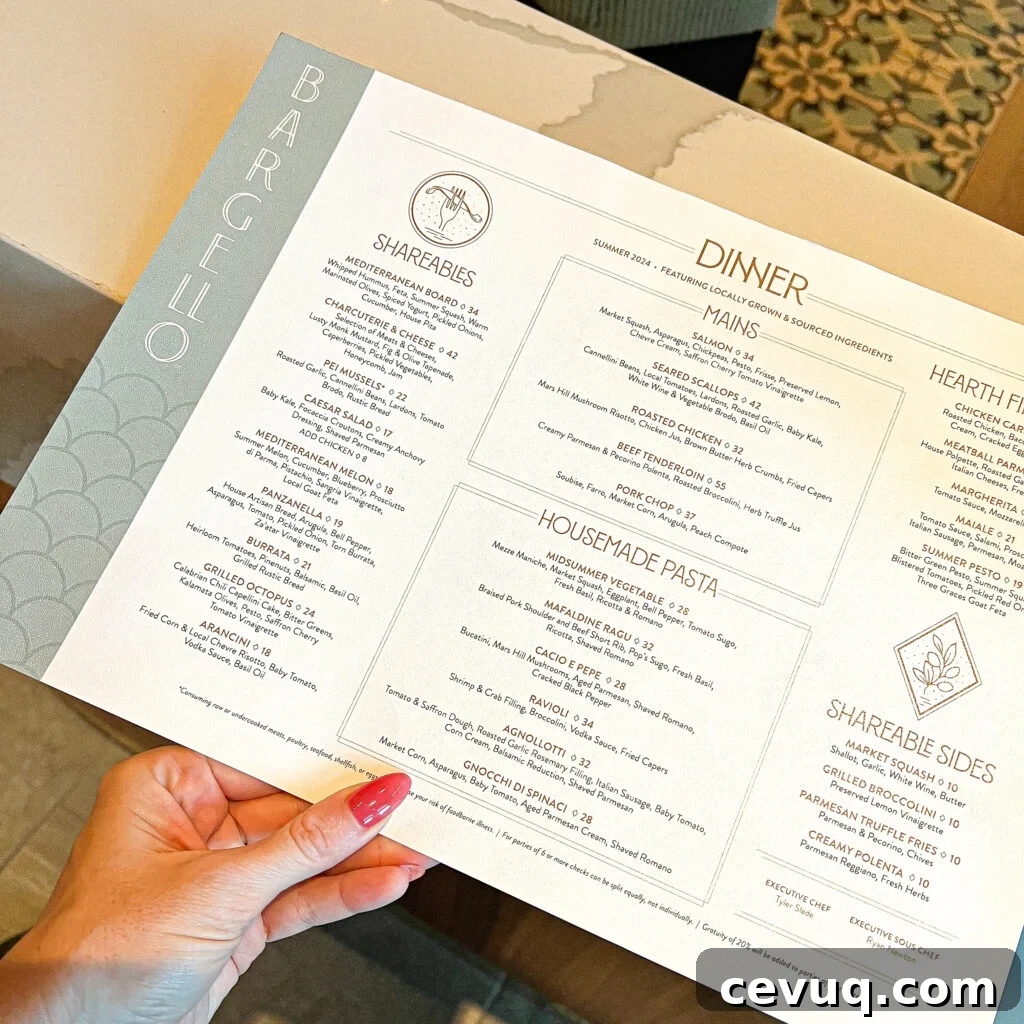A hand holding a printed dinner menu with shareables, mains, and pastas.