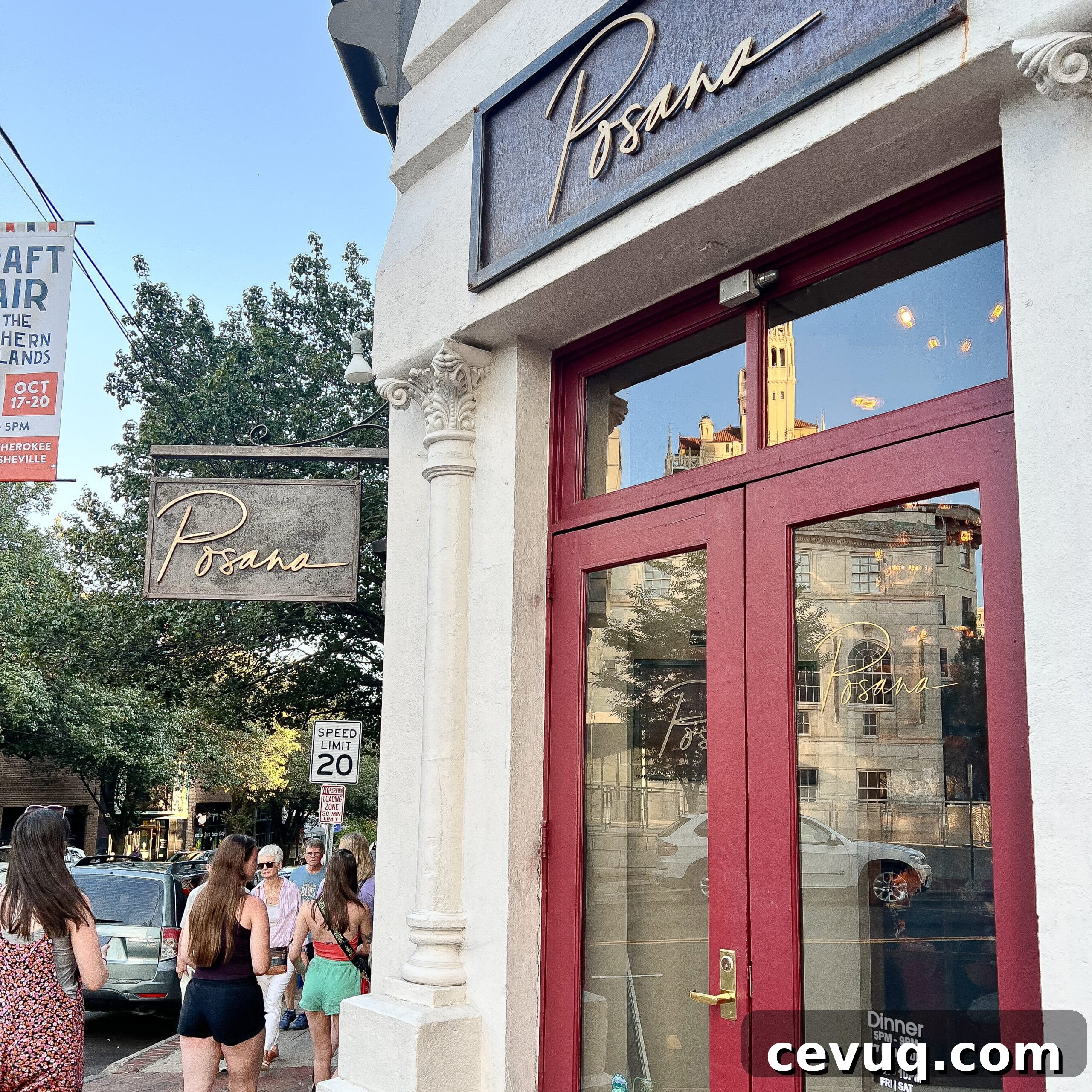 Street view of a restaurant entrance with red-framed glass doors.