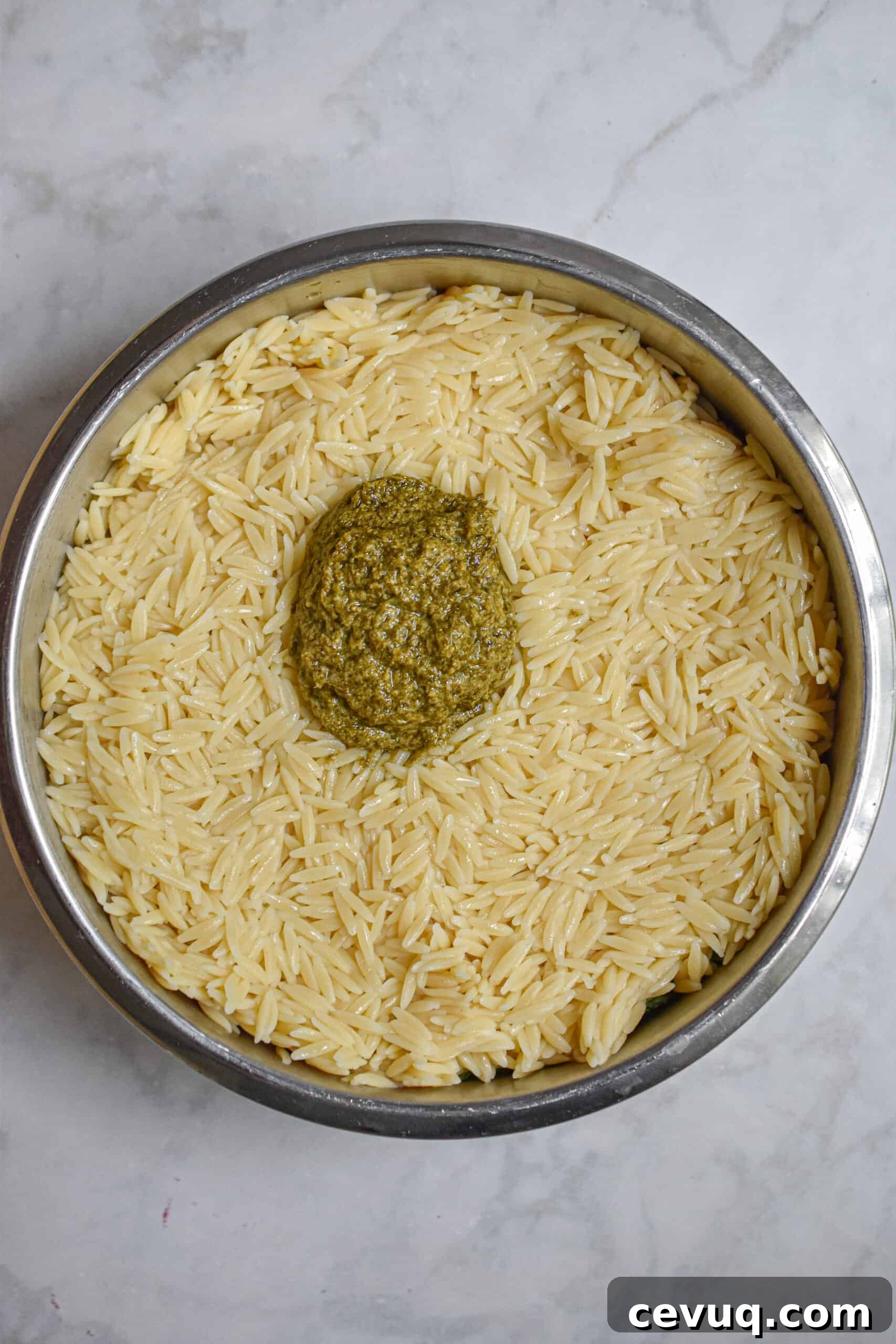 Add the orzo and pesto to the bowl