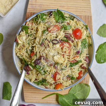 Orzo Pesto Pasta salad on a wooden cutting board