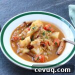 A bowl of Vegan Irish Stew with spoon, napkin, and pepper mill