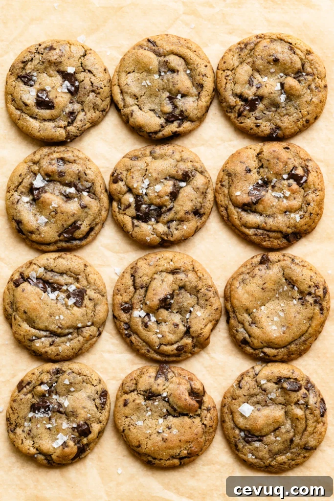 Bakery-Style Chocolate Chip Cookies Recipe for Perfect Texture 12 Twelve baked chocolate chip cookies on a piece of parchment paper.