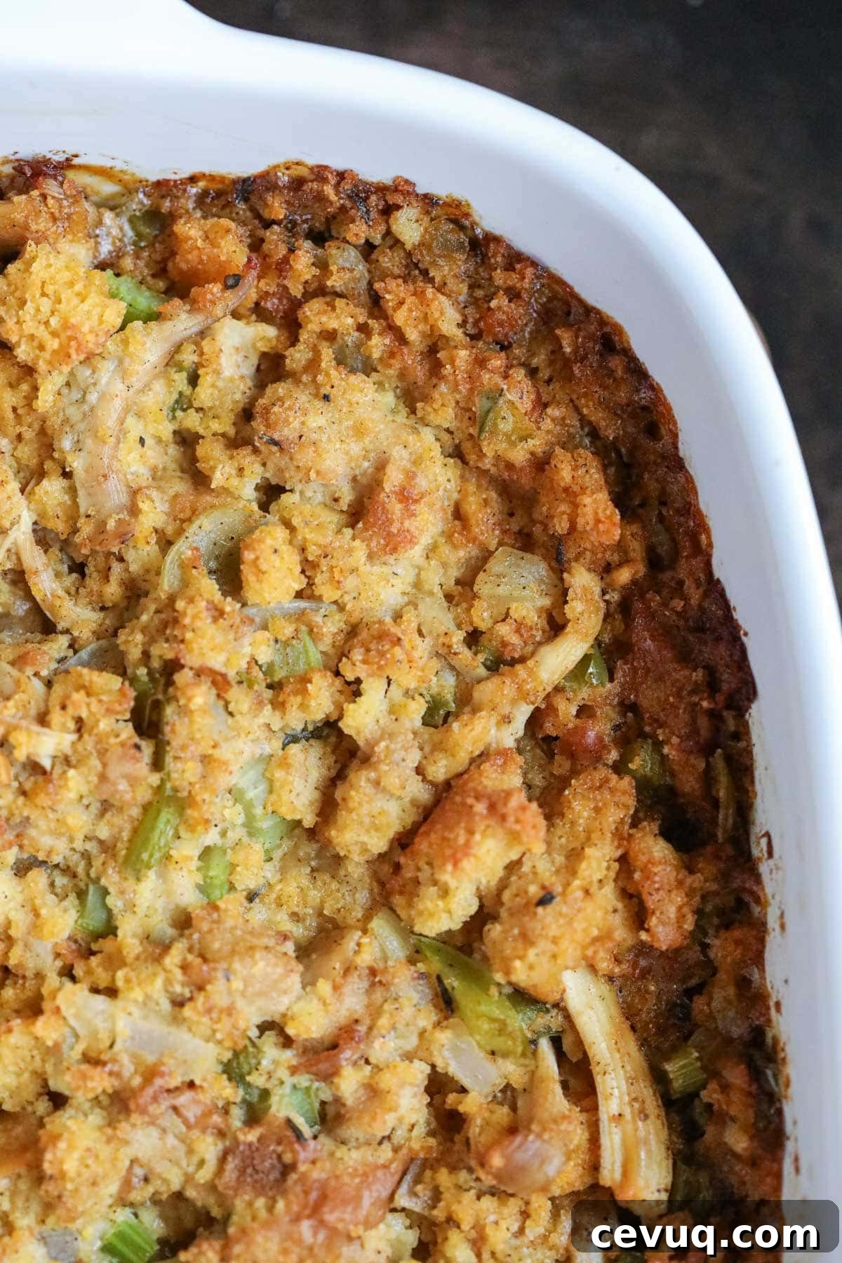 overhead detail shot of cornbread dressing in a white pan.