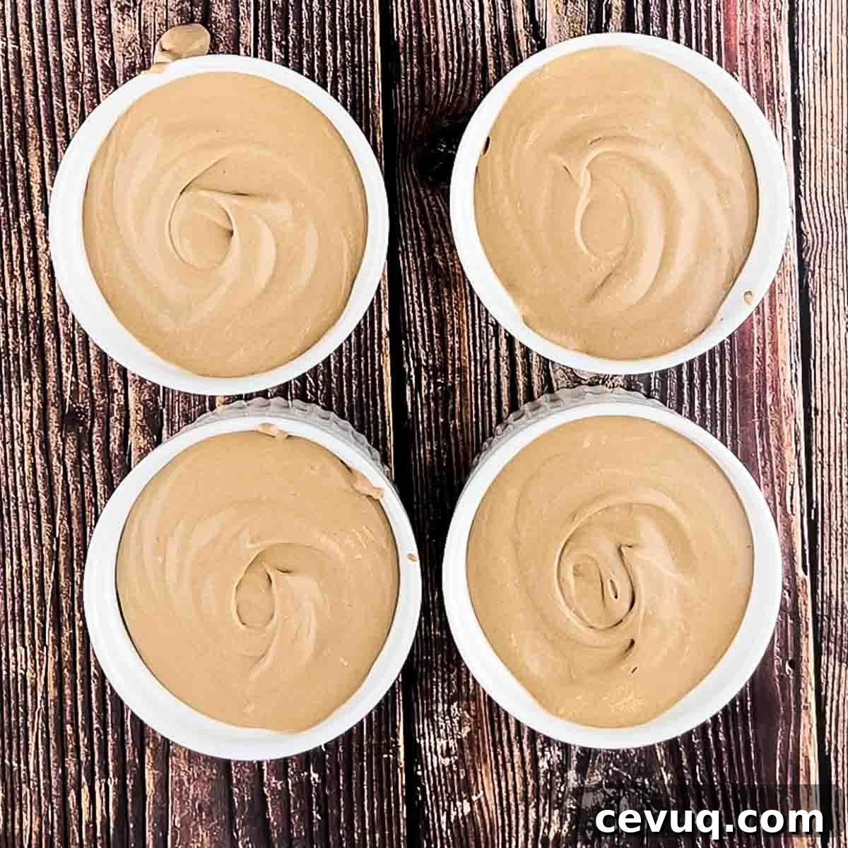 The coffee mousse spooned into four white ramekins.