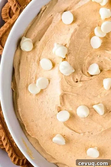 Creamy 3 ingredient pumpkin fluff in a serving bowl, topped with white chocolate chips.