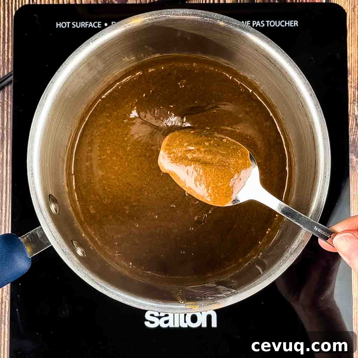 The hot mixture in a saucepan, coating the back of a spoon to show it is done.